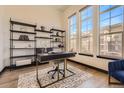 Well-lit office space featuring large windows, hardwood floors, and stylish black shelving at 7837 Inverness Blvd, Englewood, CO 80112