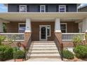 Inviting front porch with classic white columns, brick accents, and an elegant entry door at 10109 E 28Th Ave, Denver, CO 80238