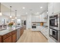 Gourmet kitchen with stainless steel appliances, white cabinets, and a spacious island with seating at 9805 Keenan St, Highlands Ranch, CO 80130