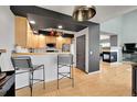 Kitchen with light wood cabinets, breakfast bar, and stainless steel appliances at 5906 S Youngfield Way, Littleton, CO 80127