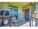 Outdoor porch has cozy seating, a sliding glass door, and decorative stone accents at 5906 S Youngfield Way, Littleton, CO 80127