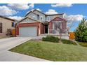 Beautiful home features a brick and gray exterior, two-car garage, with a well-maintained lawn at 12917 Fox St, Westminster, CO 80234