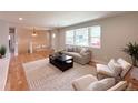 Comfortable living room featuring a large window, hardwood floors, and neutral décor at 375 Kendall St, Lakewood, CO 80226