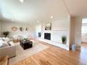 Bright living room featuring hardwood floors, a stone fireplace, and modern furnishings at 375 Kendall St, Lakewood, CO 80226