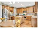 Well-lit kitchen with wooden cabinets, stainless steel appliances, and center island at 1033 Petras St, Erie, CO 80516