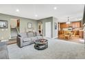 Inviting living room with a gray sofa, round coffee table, and adjacent kitchen at 1033 Petras St, Erie, CO 80516
