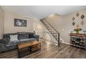 Inviting living room with wood floors, a cozy couch, and staircase access to the upper level at 8909 Field St # 102, Broomfield, CO 80021