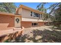 Charming two-story home featuring a brick facade, well-maintained lawn, and a welcoming front door with decorative wreath at 30321 Chestnut Dr, Evergreen, CO 80439
