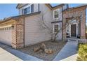 A well-maintained two-story home with brick accents, a neat lawn, and a welcoming walkway to the front door at 10215 Kleinbrook Way, Highlands Ranch, CO 80126