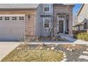 Two-story home boasts a two-car garage, brick accents, a tidy lawn, and a welcoming entrance at 10215 Kleinbrook Way, Highlands Ranch, CO 80126