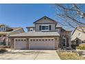 Attractive two-story home with a two-car garage, brick accents, and a well-maintained lawn under a clear blue sky at 10215 Kleinbrook Way, Highlands Ranch, CO 80126
