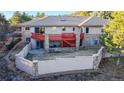 Spacious backyard with a red deck, stone accents, and a retaining wall, ideal for outdoor living at 6260 Rain Dance Trl, Littleton, CO 80125