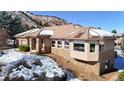 Beautiful home with a stone exterior and tile roof nestled in a scenic mountain setting at 6260 Rain Dance Trl, Littleton, CO 80125