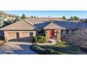 Charming ranch style home featuring a stone facade and a two-car garage nestled on a verdant lot at 6260 Rain Dance Trl, Littleton, CO 80125