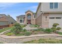 Inviting front yard with stone accents, lush landscaping, and a view of the home's exterior at 15887 W Ellsworth Ln, Golden, CO 80401