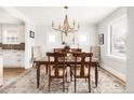 Light-filled dining room features a gold chandelier and a beautiful wood table at 945 Jackson St, Denver, CO 80206