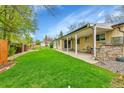 Expansive backyard featuring a lush green lawn and a covered patio perfect for outdoor relaxation at 460 S Taft St, Lakewood, CO 80228