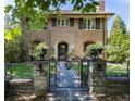 Brick home with ornate iron gate and landscaping at 559 N Williams St, Denver, CO 80218