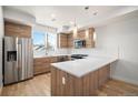 Modern kitchen featuring stainless steel appliances, wooden cabinetry, sleek countertops and stylish pendant lighting at 3520 W Conejos Pl # 11, Denver, CO 80204