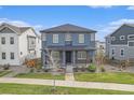Two-story home with a covered porch and a well-maintained lawn and landscaping at 10610 Reunion Pkwy, Commerce City, CO 80022