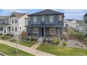 Well-maintained two-story home with a covered porch and landscaping at 10610 Reunion Pkwy, Commerce City, CO 80022