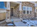 Inviting front entrance with a decorative wreath, stone accents, and well-maintained landscaping, creating a welcoming curb appeal at 745 N Tempe St, Aurora, CO 80018