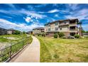 Scenic shot of condo complex with a walking path, lush greenery, and clear blue sky at 12820 Ironstone Way # 103, Parker, CO 80134
