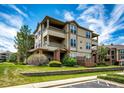 Attractive exterior view of multi-story condo complex with manicured landscaping, lawn and blue skies at 12820 Ironstone Way # 103, Parker, CO 80134