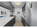 Modern kitchen with sleek, dark cabinetry, stainless steel appliances, and white countertops at 2 Adams St # 806, Denver, CO 80206