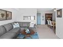 Cozy living room with blue accent rug opens to dining area; gray sectional sofa at 2 Adams St # 806, Denver, CO 80206