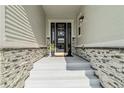 A welcoming covered front entryway boasting stone accents and a black front door flanked by planters at 1581 Diamond Hill Ct, Castle Rock, CO 80104