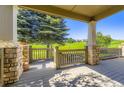 Covered back porch with stone columns overlooking a lush green space, providing a serene outdoor retreat at 23738 E Clifton Pl, Aurora, CO 80016