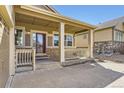 Covered front porch with classic railings and columns, offering a welcoming entrance at 23738 E Clifton Pl, Aurora, CO 80016