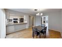Open-concept dining area adjacent to the kitchen, featuring hardwood floors and a stylish chandelier at 1050 S Monaco Pkwy # 38, Denver, CO 80224