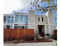 Charming townhome featuring a fenced front yard, classic siding, and bright windows at 1050 S Monaco Pkwy # 38, Denver, CO 80224
