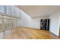 Spacious living room featuring hardwood floors, a high ceiling, and large windows for ample natural light at 1050 S Monaco Pkwy # 38, Denver, CO 80224