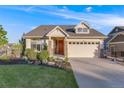 Well-maintained home with a manicured lawn and a welcoming two-car garage in a suburban setting at 19688 E 52Nd Ave, Denver, CO 80249