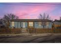 Charming exterior view of a light blue home with a picket fence and arched entrance at 441 Johnson St, Frederick, CO 80530