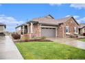 Charming single-Gathering home featuring a stone exterior, attached garage, and beautifully landscaped lawn at 24943 E Phillips Pl, Aurora, CO 80016