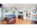 Cozy living room with hardwood floors, ceiling fan, and a view into the eat-in kitchen at 11261 Clarkson St, Northglenn, CO 80233