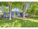 Inviting home exterior with vibrant blue siding, large trees, and a walkway leading to the cozy front porch at 2684 S Adams St, Denver, CO 80210