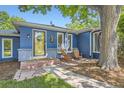 Close-up of the blue home's entrance, featuring a stylish front door and charming outdoor seating area at 2684 S Adams St, Denver, CO 80210