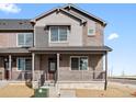 Beautiful two-story townhome showcasing a welcoming front porch and a combination of brick and siding at 6504 N Malaya St, Aurora, CO 80019