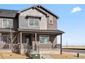 Inviting two-story townhome with a covered porch, showcasing a blend of brick and siding finishes at 6504 N Malaya St, Aurora, CO 80019