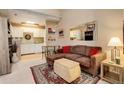Living room with an open layout, neutral decor, light carpet, and a view of the adjoining kitchen at 4931 Garrison St # 204G, Wheat Ridge, CO 80033