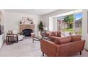 Bright and airy living room with a cozy brick fireplace, large windows, and stylish furnishings at 20396 E Berry Pl, Centennial, CO 80015