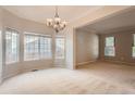 Open dining room area with a chandelier, carpeted floor, and lots of natural light from large windows at 20431 E Union Cir, Aurora, CO 80015