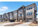 Stylish townhomes with stone facade, private balconies, and attractive landscaping with driveways for parking at 4355 Cyan Cir # E, Castle Rock, CO 80109