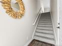 Carpeted staircase with decorative mirror, and white walls, adding a touch of elegance to the home's entrance at 4355 Cyan Cir # E, Castle Rock, CO 80109