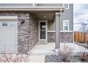 The front entrance features stone veneer accents, covered porch, and manicured landscaping at 3918 S Rome Ct, Aurora, CO 80018